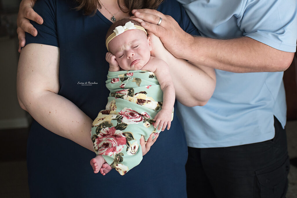 Prosper Newborn Photographer captures a newborn baby girl with a frown.