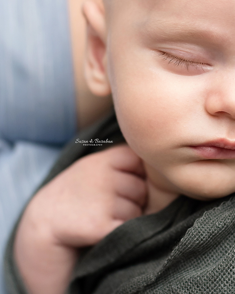 Close up detail image of newborn baby boy's long eyelashes.